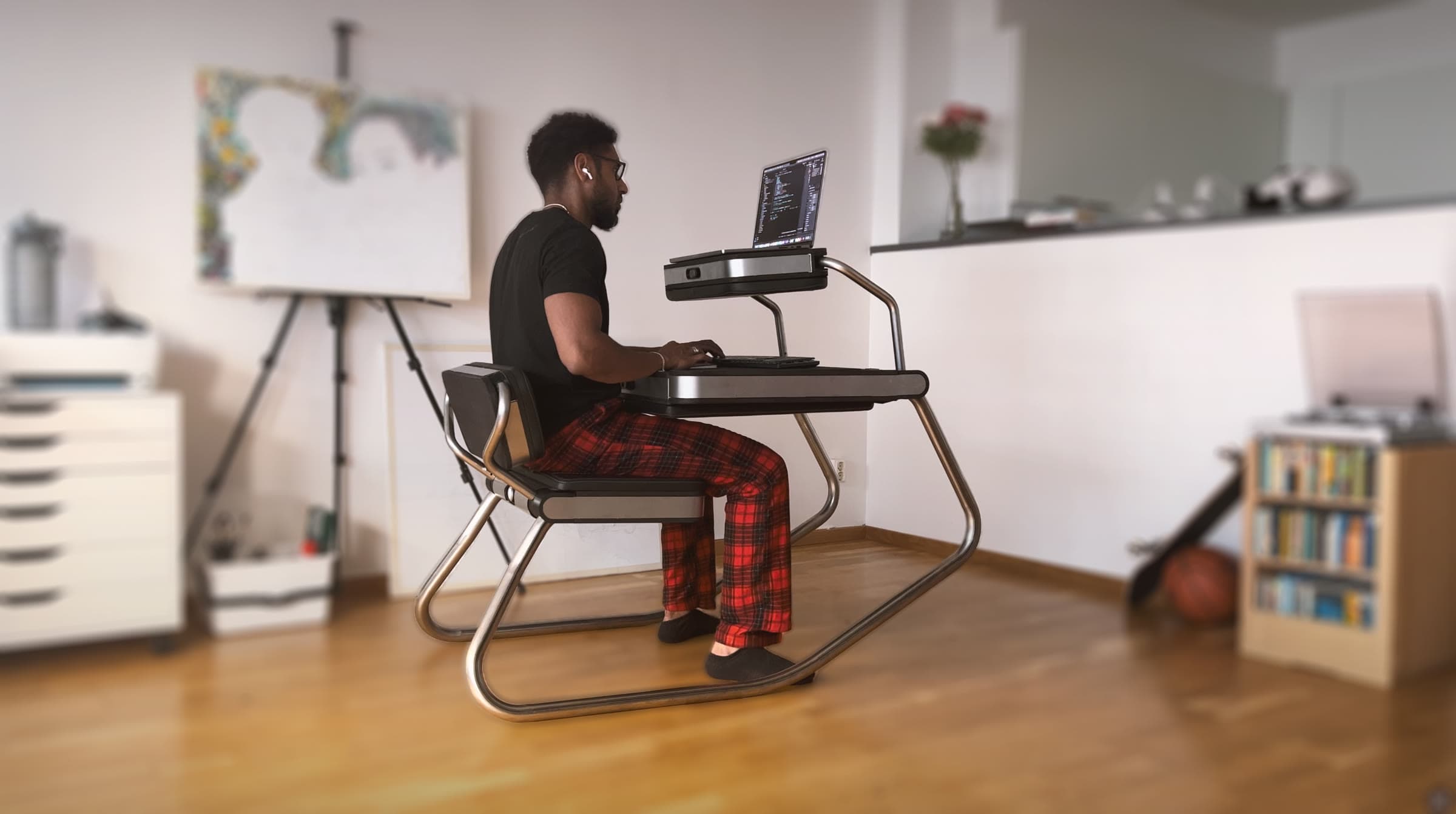 Photo of the Zero da Vinci steel prototype in desk mode, a man working at a laptop on it